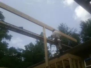 Carpenter setting a ridge beam over a new addition frame — Ice Dam Removal by Roofing Brothers in Union Mills