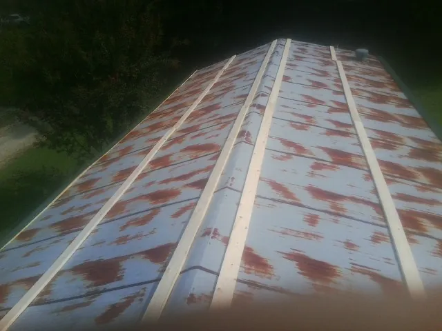 Rusted metal roof panels with new wood purlins before replacement — Storm Damage Roof Repair in Union Mills by Roofing Brothers