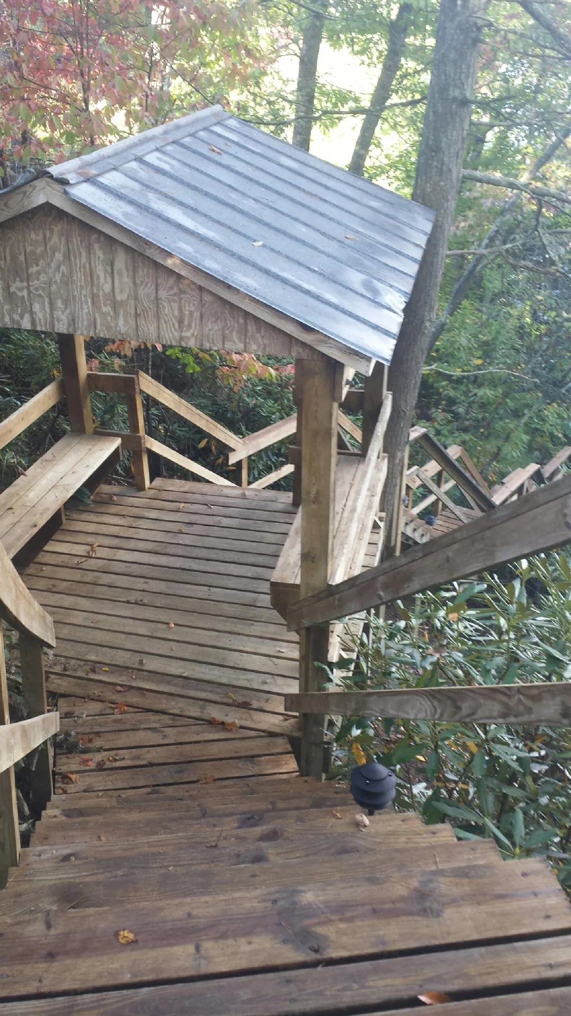 Metal roofed shelter over wooden steps on a wooded walkway — Skylight Repair & Installation work by our crew in Union Mills