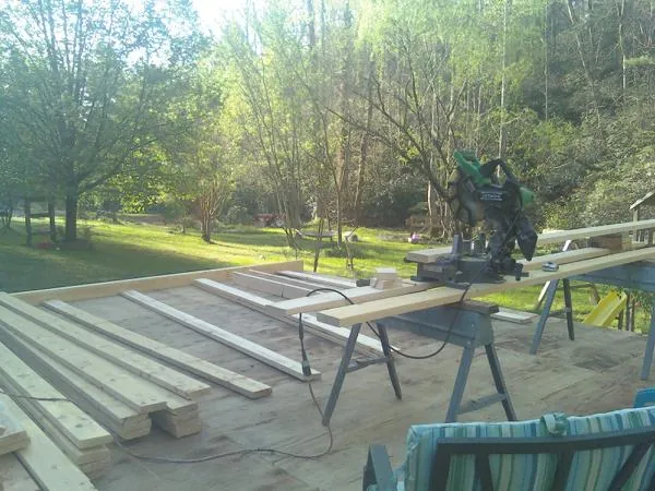Miter saw and framing lumber on a deck under construction in Union Mills